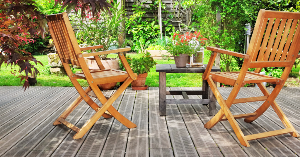 Terrasse en bois avec lames rainurées et mobilier de jardin dans un jardin fleuri à Marans.