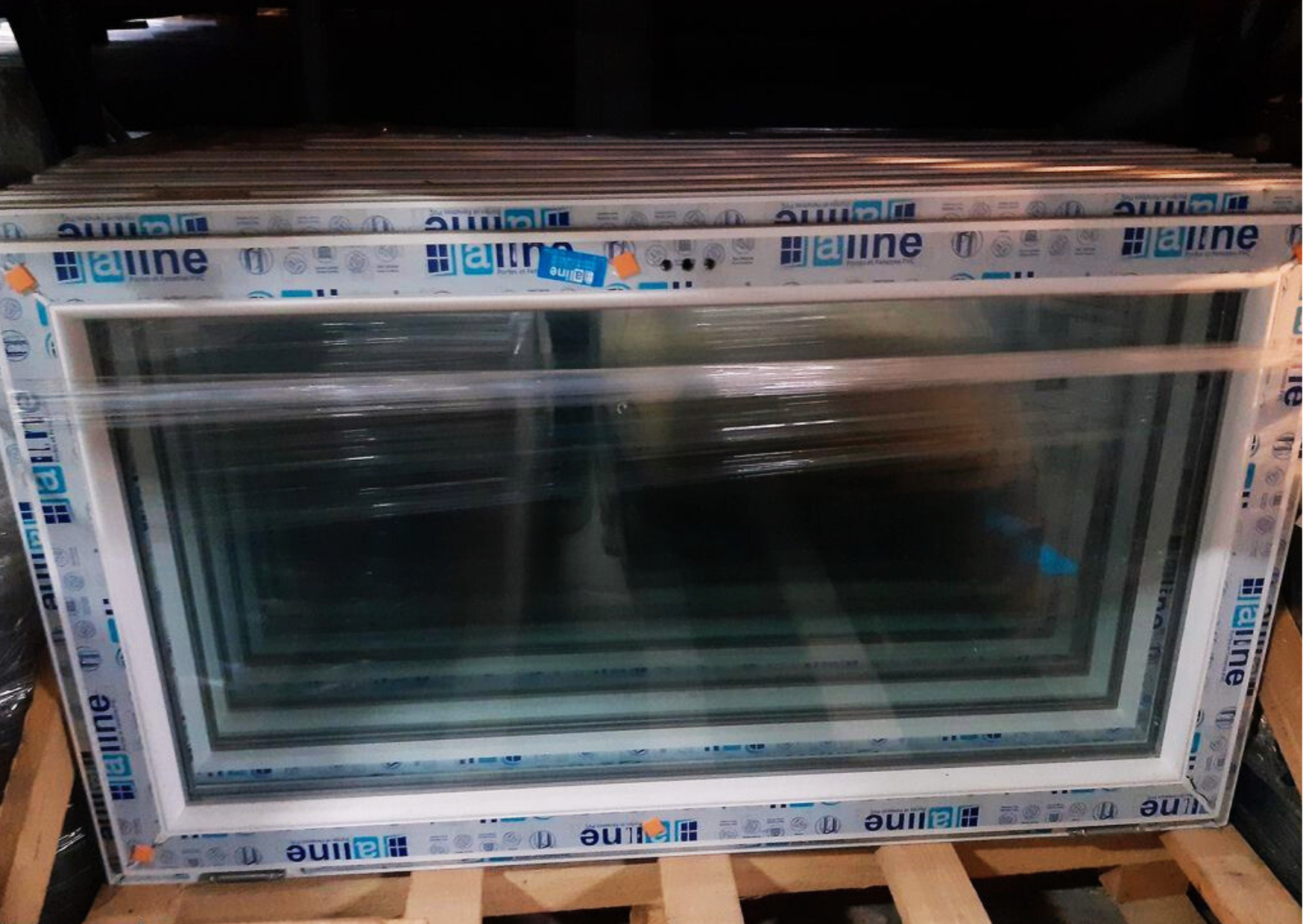 Gros plan sur un châssis fixe en PVC blanc avec double vitrage haute isolation prêt pour la livraison.