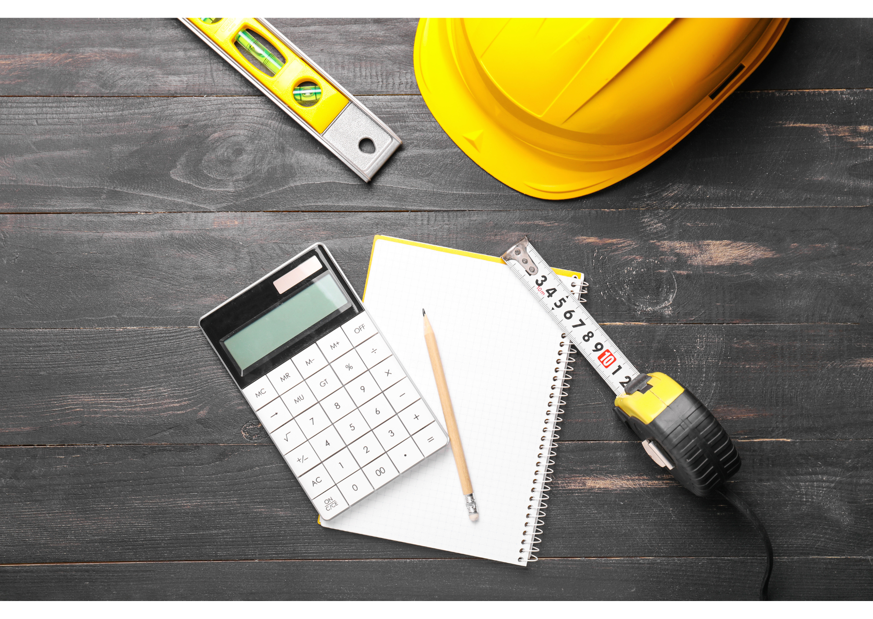 Calculatrice, mètre ruban et casque de chantier pour réaliser un devis de matériaux bois.