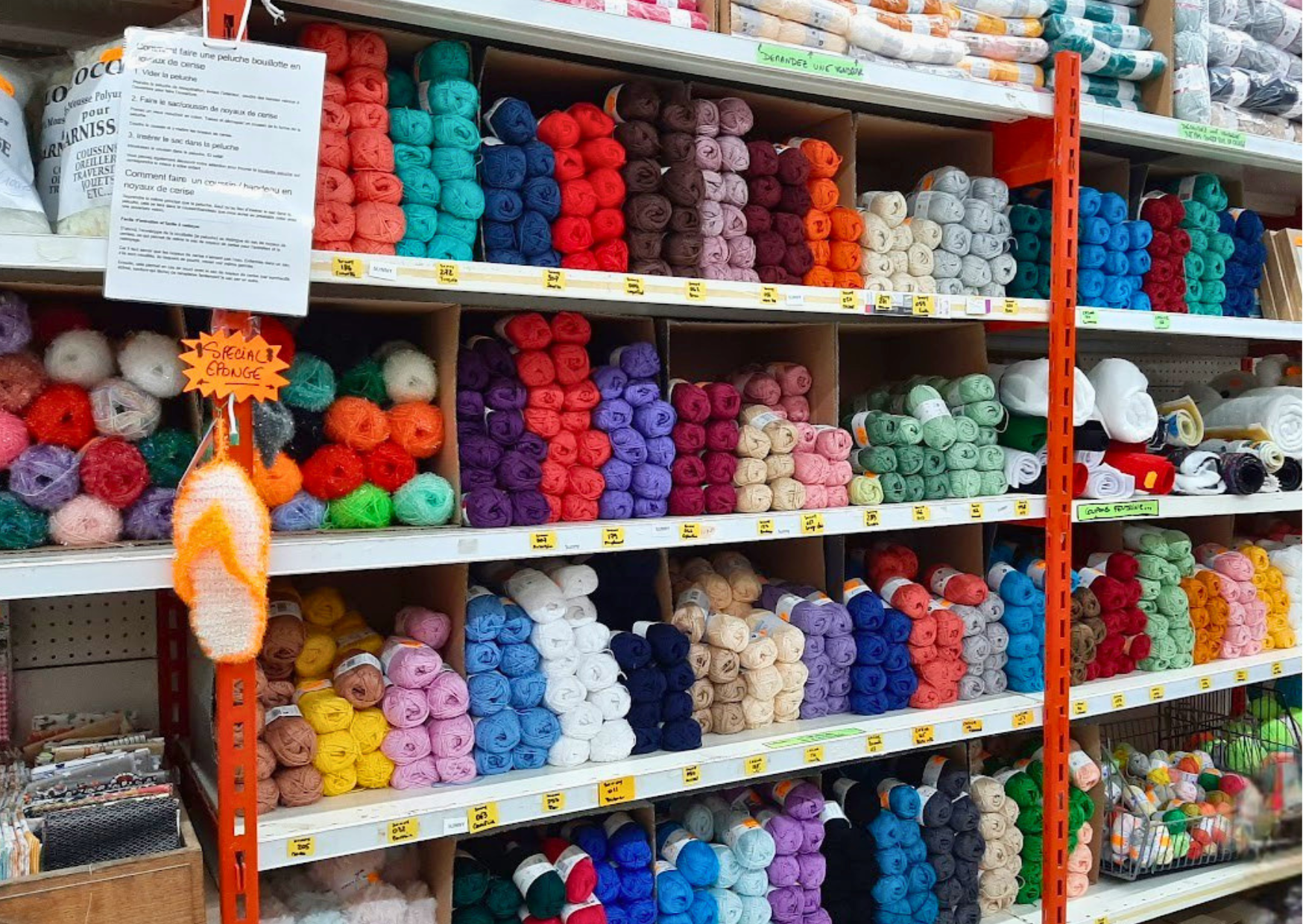 Étagères de pelotes de laine toutes couleurs pour le tricot, le crochet et les loisirs créatifs disponibles chez Le Marais Fleuri.
