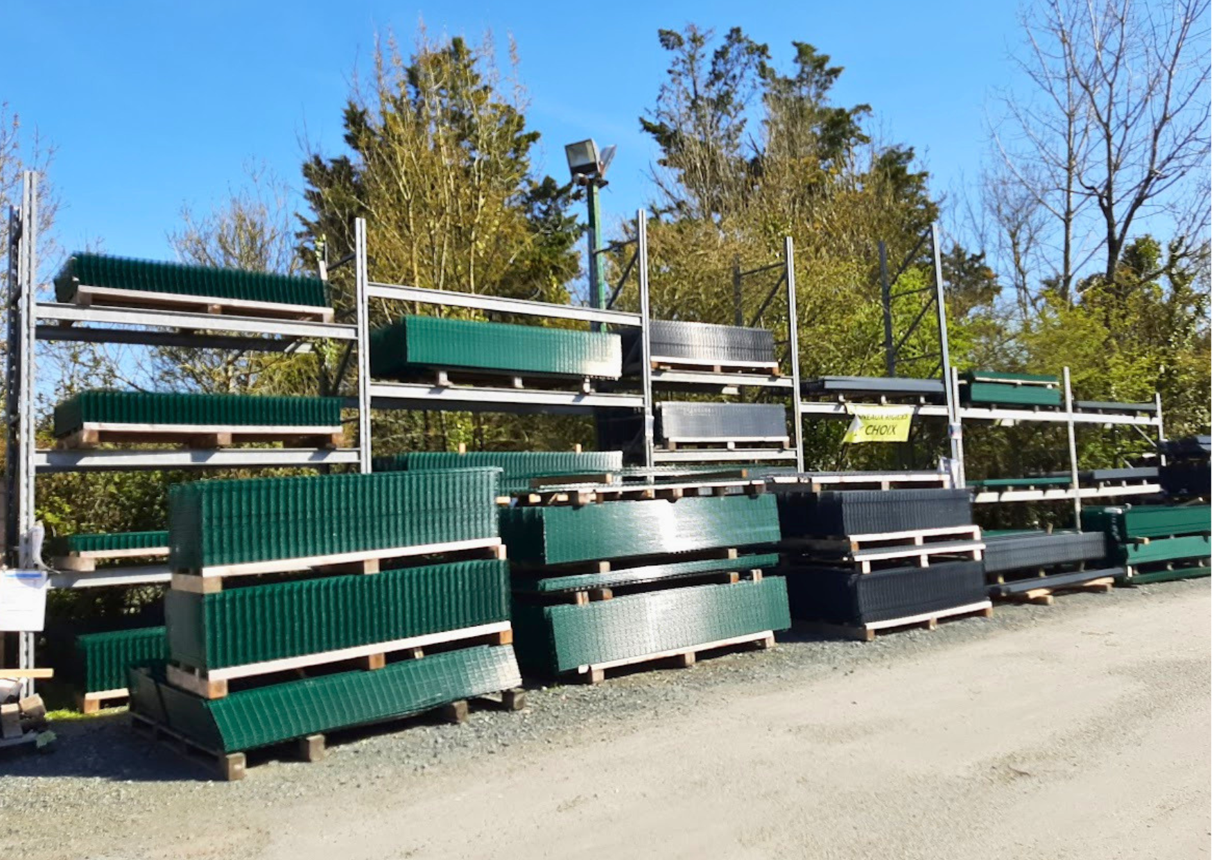 Racks de stockage extérieurs avec palettes de panneaux rigides verts et gris anthracite chez Marais Fleuri à Marans (17) et Mareuil-sur-Lay (85).