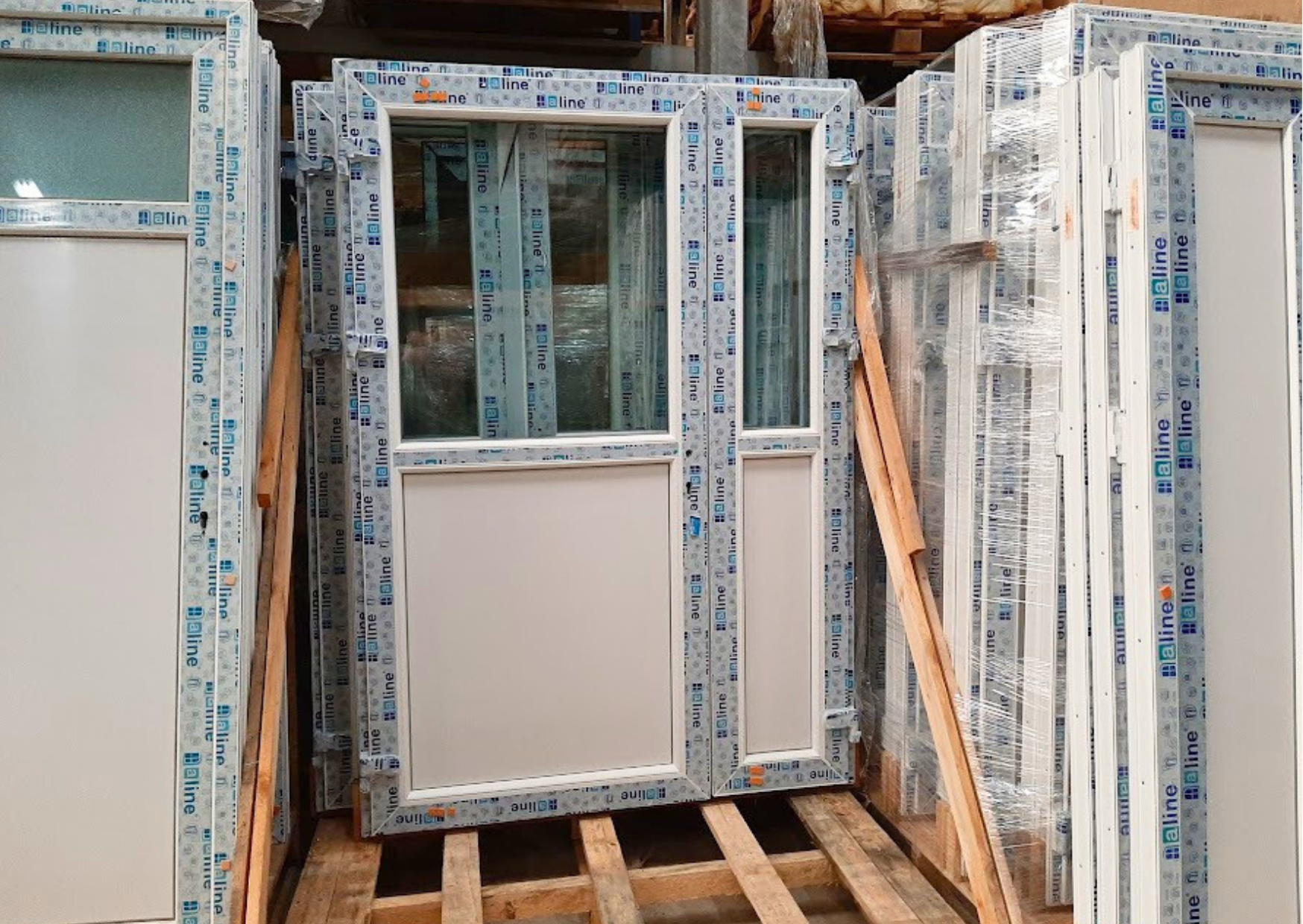 Porte de service ou d'entrée tiercée à 2 vantaux asymétriques en PVC blanc avec double vitrage supérieur et soubassement plein, en stock chez Marais Fleuri à Marans.