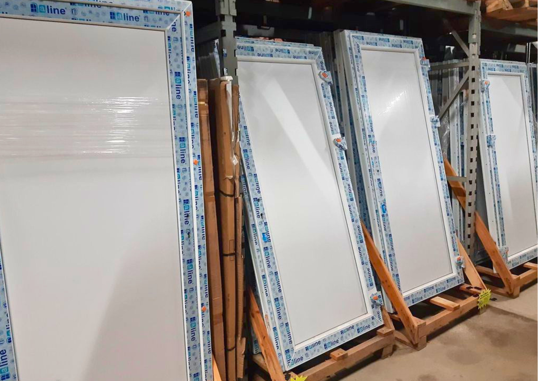 Alignement de portes-fenêtres vitrées et portes de service en PVC blanc neuves en stock chez Marais Fleuri.