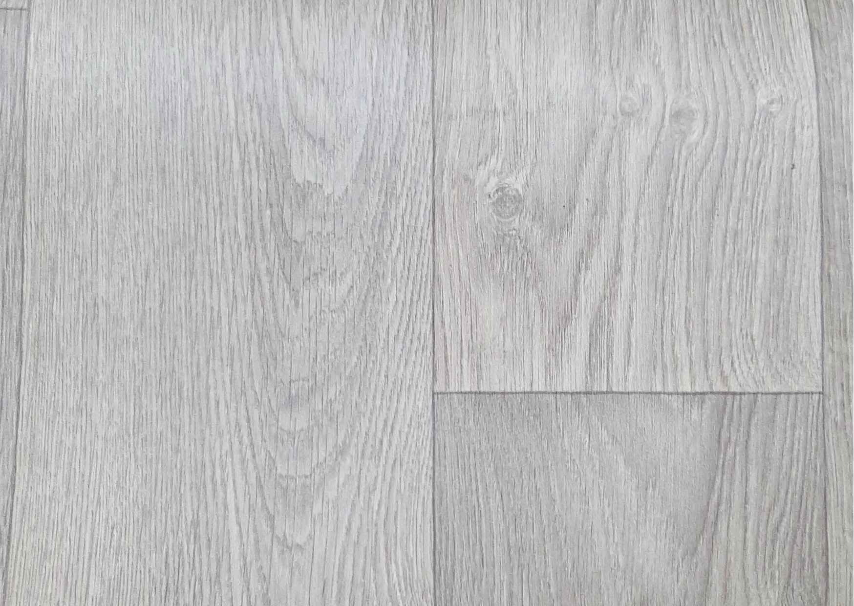 Gros plan sur un revêtement de sol imitation parquet bois chêne clair et gris avec veinage naturel chez Marais Fleuri.