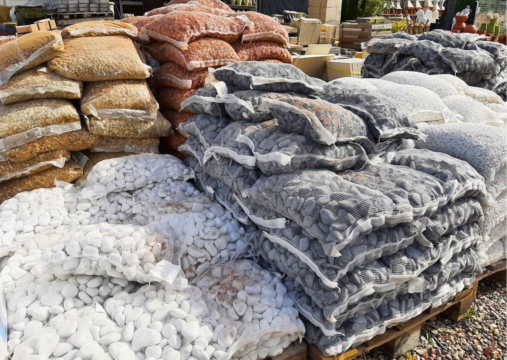 Sacs de galets blancs, graviers noirs et paillage minéral pour aménagement paysager en stock chez Marais Fleuri.
