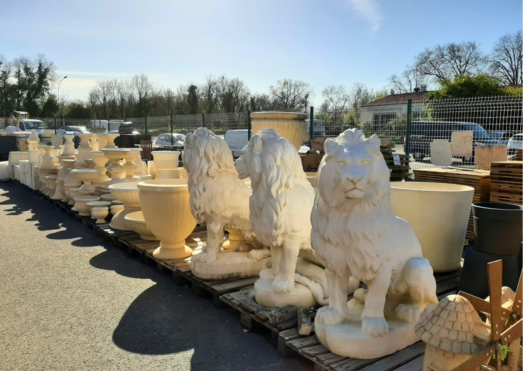 Statues de lions et vasques décoratives en pierre reconstituée pour aménagement de jardin chez Marais Fleuri.