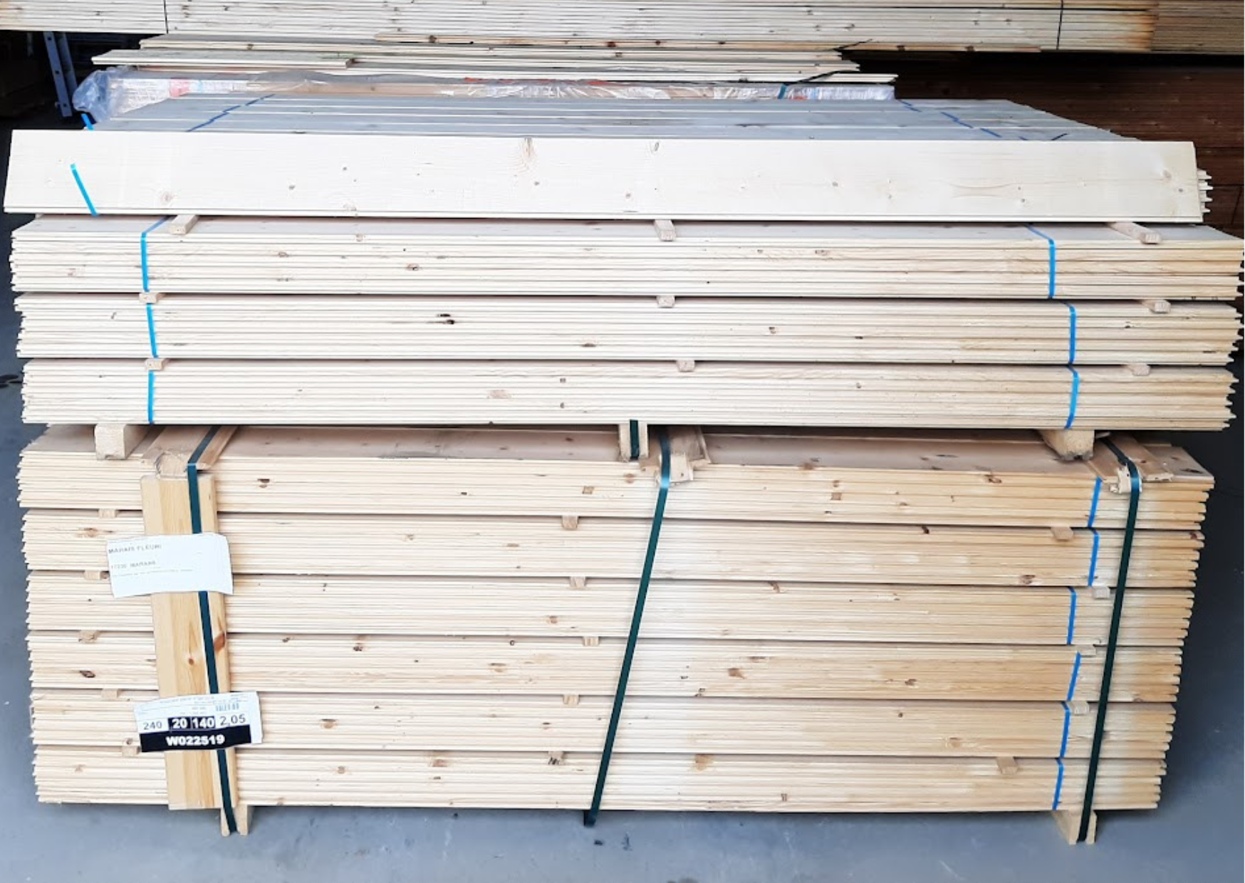 Palette de lames de parquet en bois massif clair prêtes pour la pose de planchers chez Marais Fleuri à Marans (17) et Mareuil-sur-Lay (85).